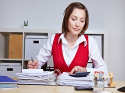 Business woman doing a tax audit in the office with files and calculator